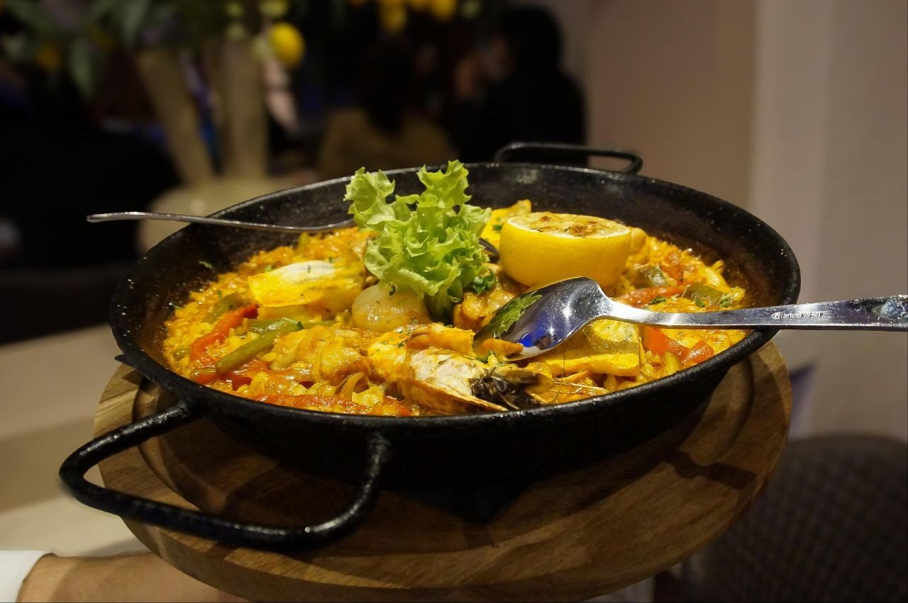 Paella Tierra y Mar in der Pfanne am Tisch serviert
